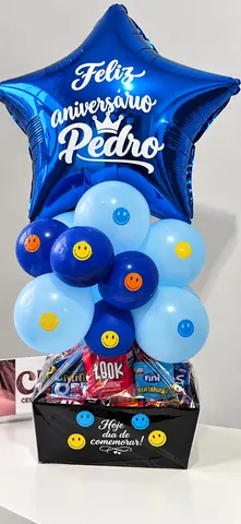 Cesta Smile: estrela azul escrito Feliz aniversário Pedro, topo de balões azuis e cesta preta com chocolates
